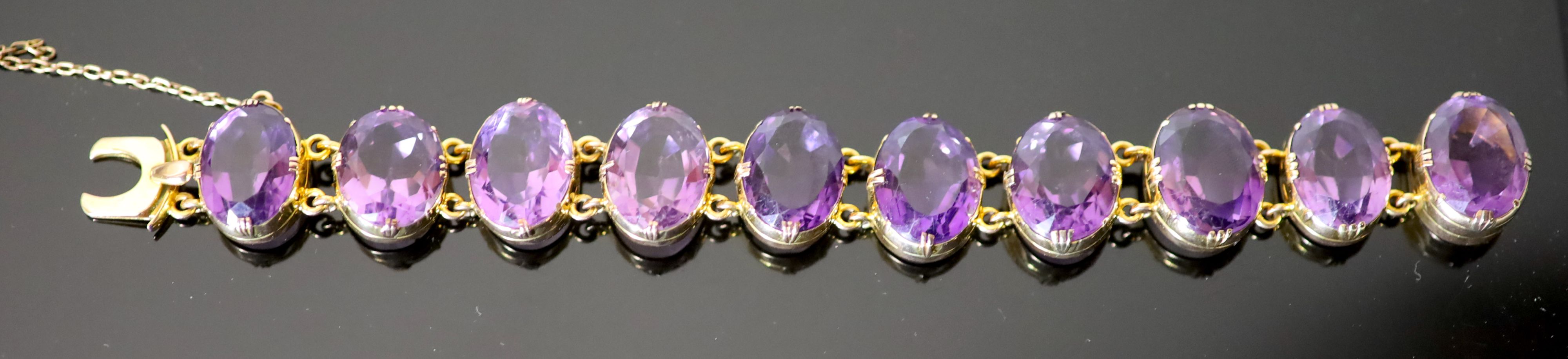 A Victorian style gold and ten stone oval cut amethyst set bracelet,